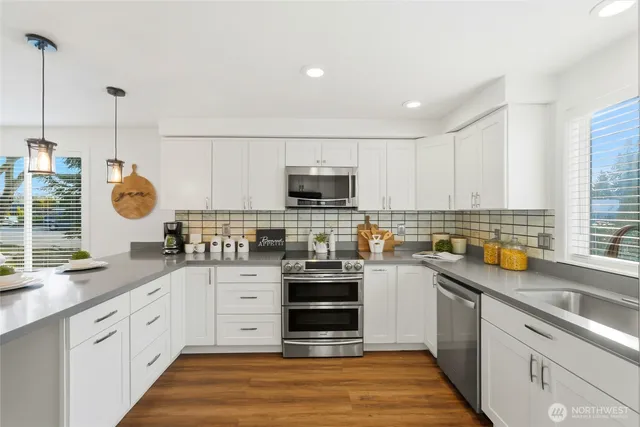 a kitchen with stainless steel appliances a stove sink and microwave