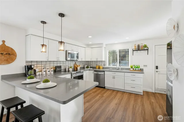 a kitchen with a sink appliances and living room view