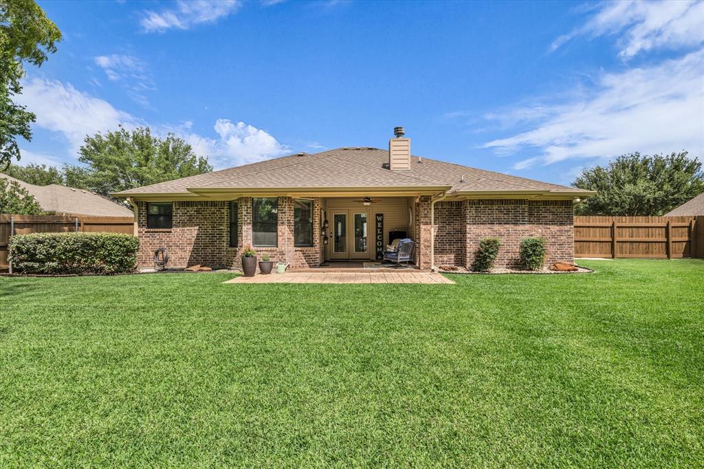 814 Springdale Circle Lorena, TX 76655 - Photo 34 of 37 Expansive backyard featuring a lush lawn, a covered patio with a brick-patterned hardscape, and a full brick exterior