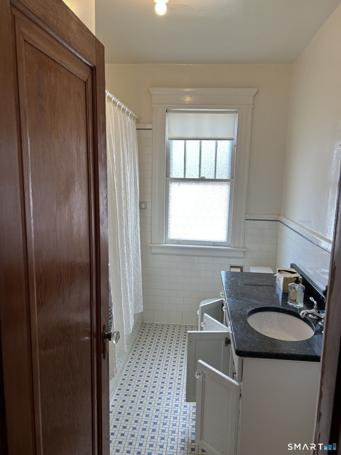 41 Lawlor Street Waterbury, CT 06708 - Photo 9 of 11 The bathroom has white subway tile on the walls, ceramic floor tile and frosted bathroom windows.