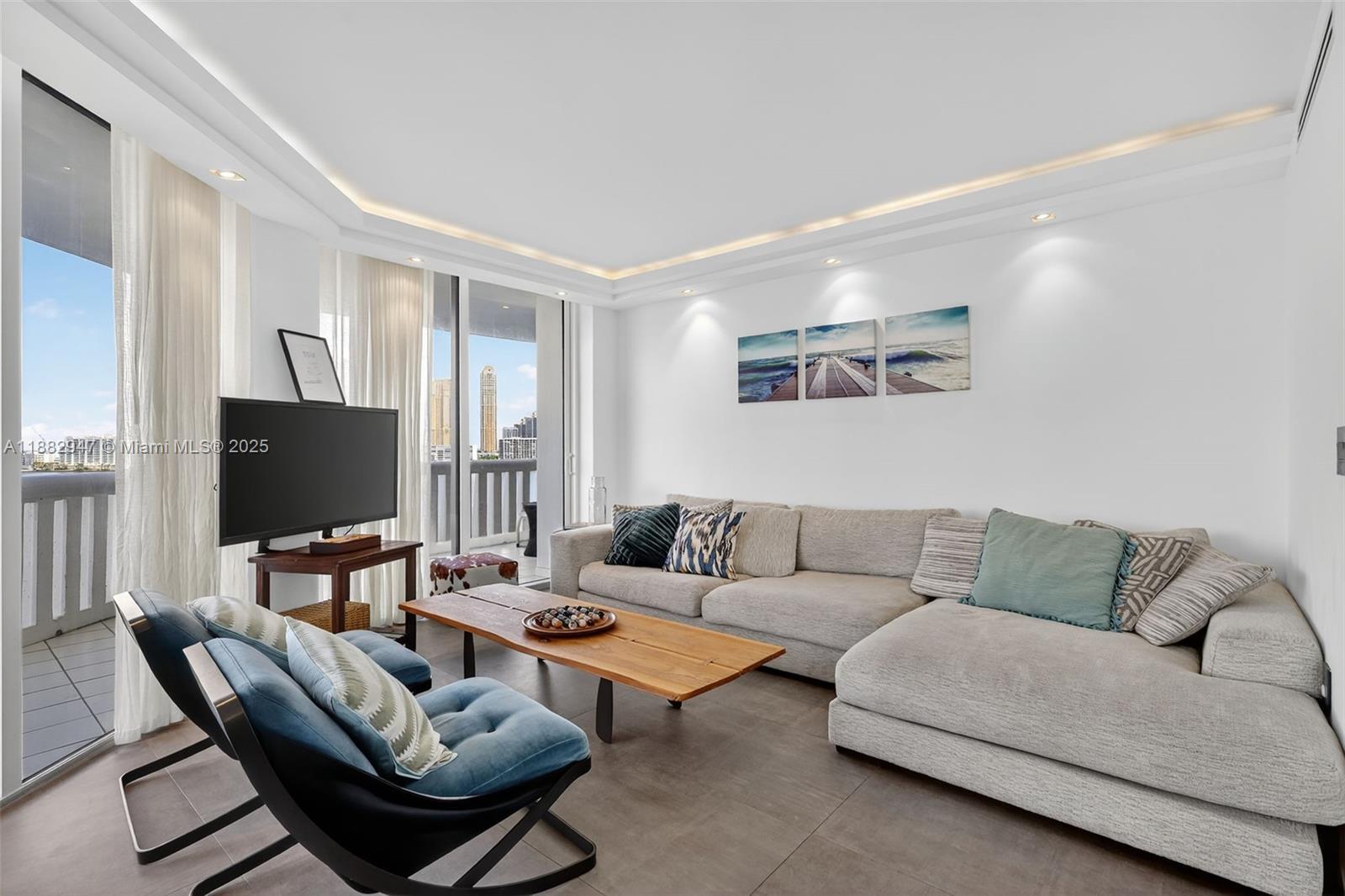 3000 Island Boulevard, Unit 906 Aventura, FL 33160 - Photo 16 of 58 a living room with furniture and a flat screen tv