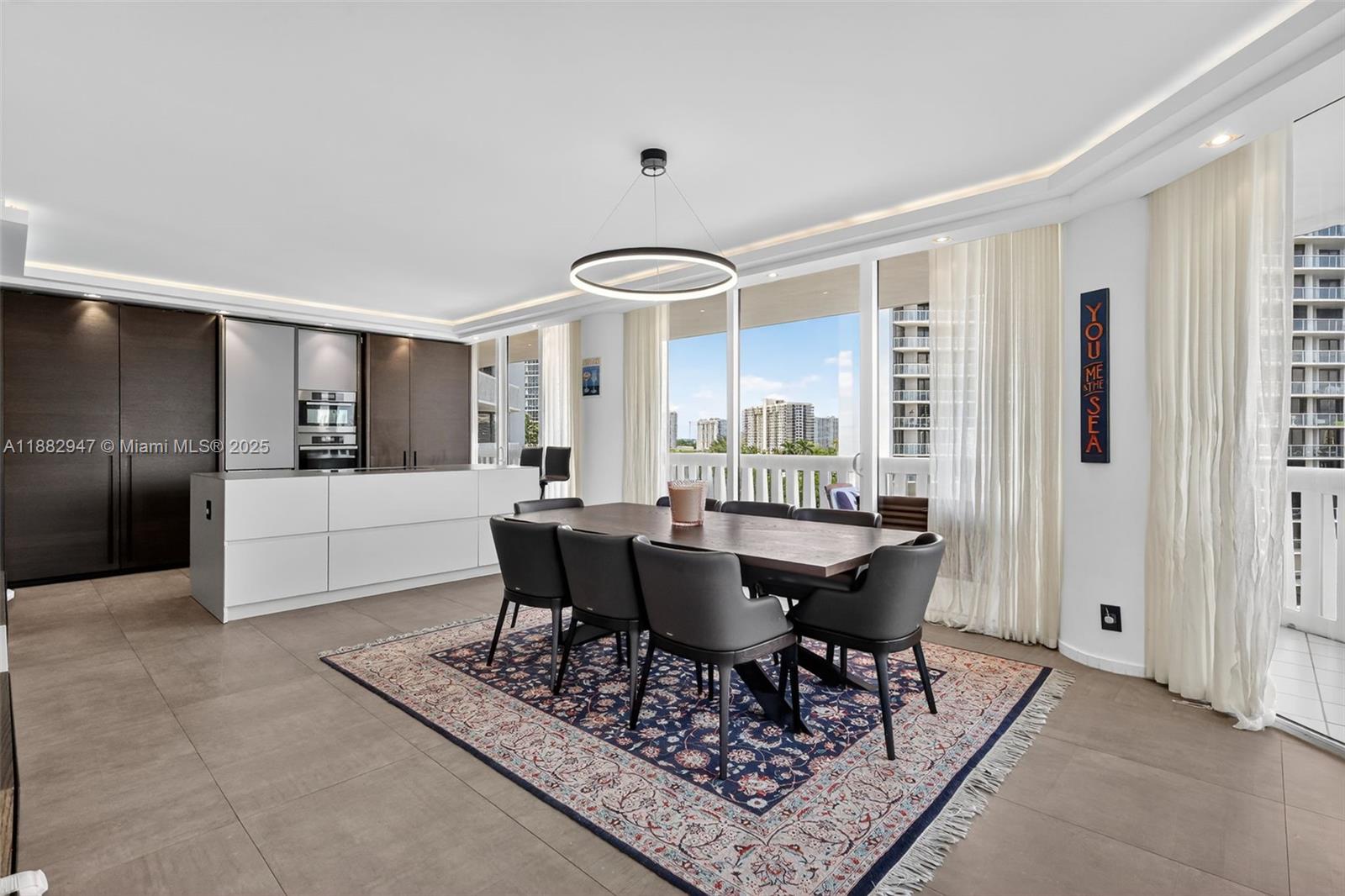 3000 Island Boulevard, Unit 906 Aventura, FL 33160 - Photo 20 of 58 a living room with furniture a rug and kitchen view