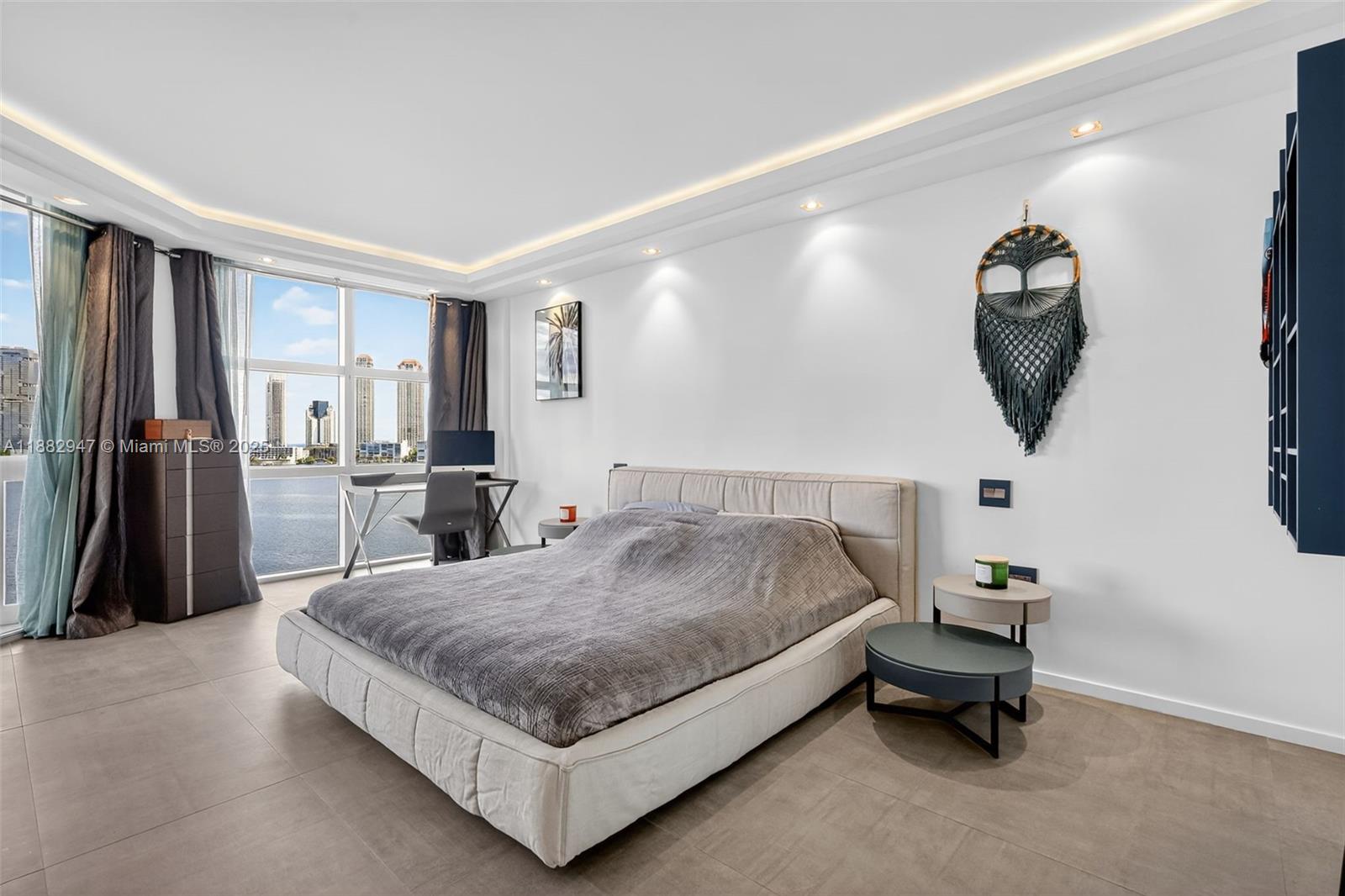 3000 Island Boulevard, Unit 906 Aventura, FL 33160 - Photo 23 of 58 a spacious bedroom with a bed and a chandelier