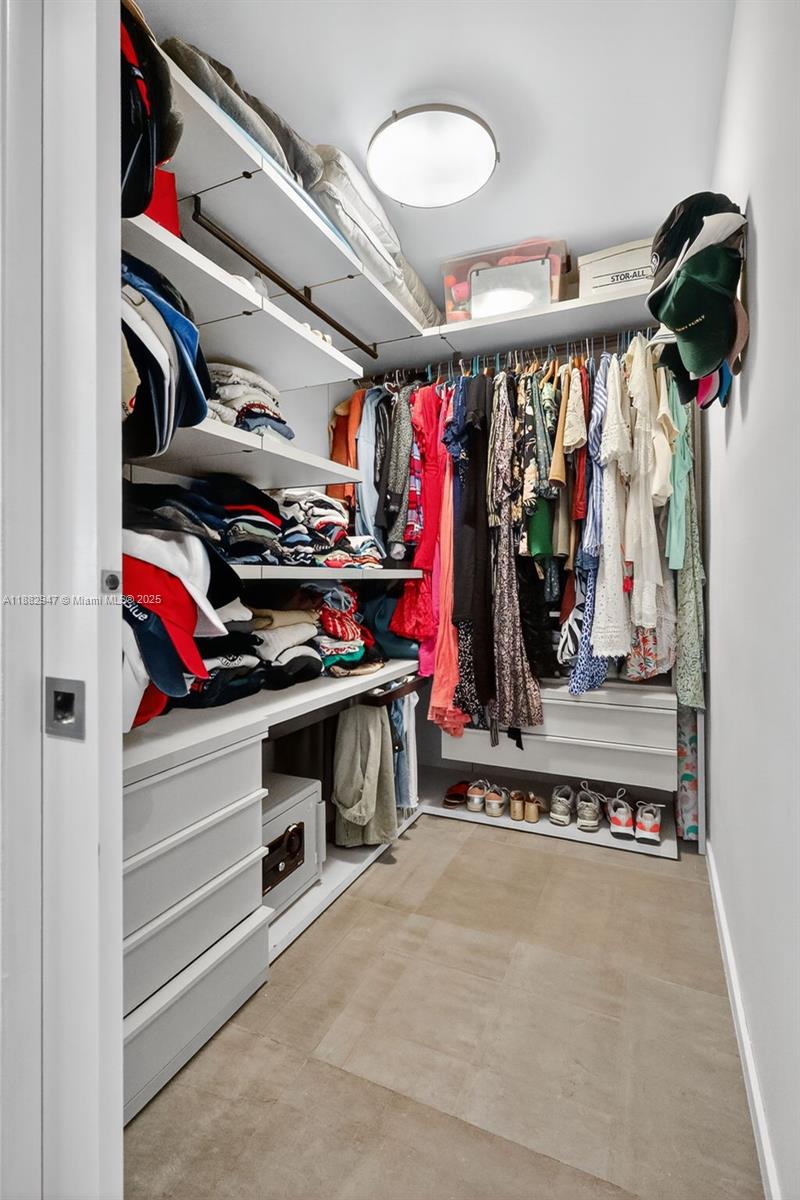 3000 Island Boulevard, Unit 906 Aventura, FL 33160 - Photo 28 of 58 a view of walk in closet with clothes and shoes