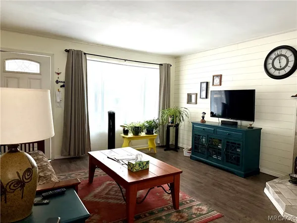 a living room with furniture a flat screen tv and a window