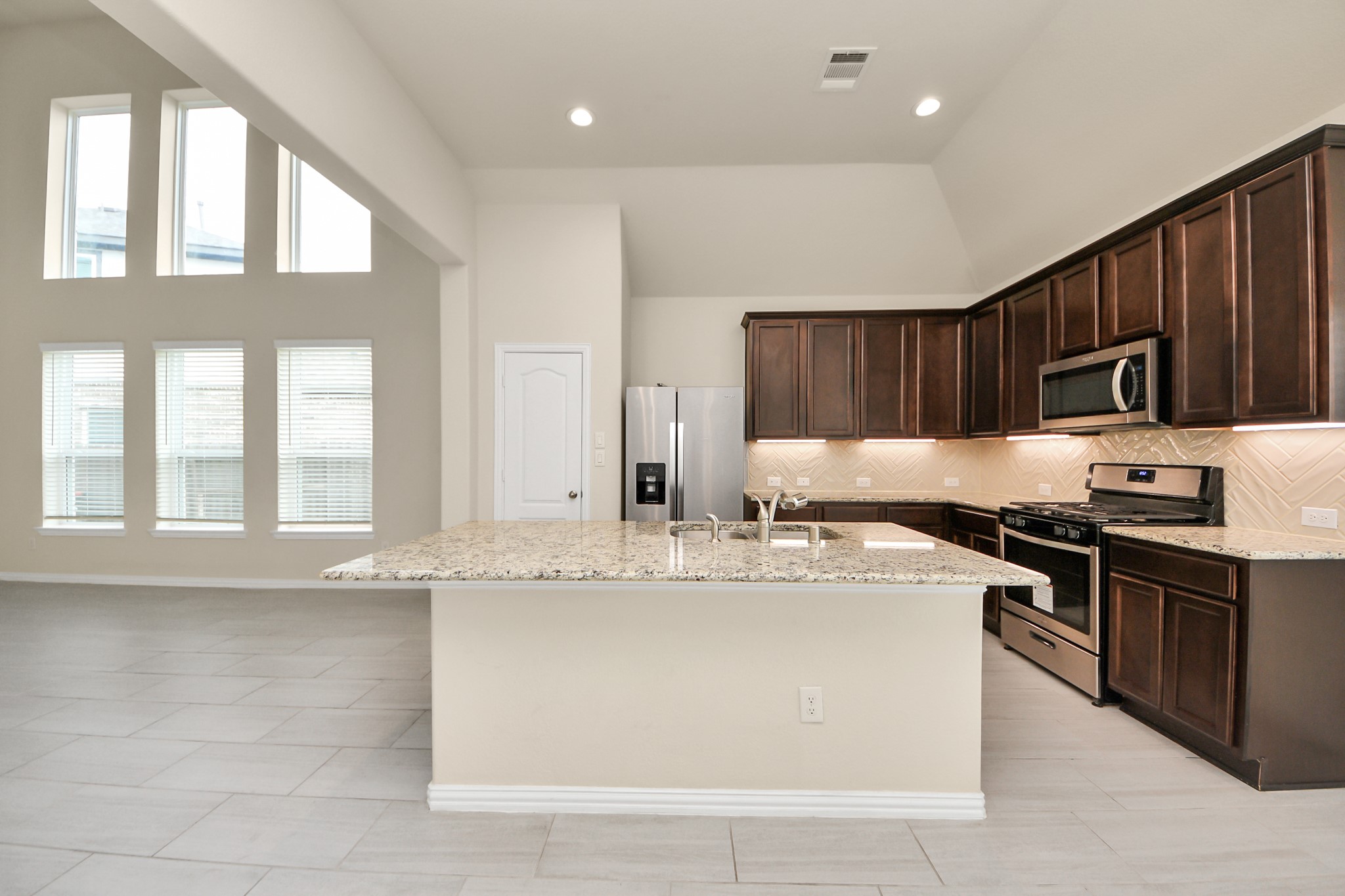 32903 Silver Meadow Way Brookshire, TX 77423 - Photo 12 of 40 a kitchen with stainless steel appliances granite countertop a stove a sink and a microwave