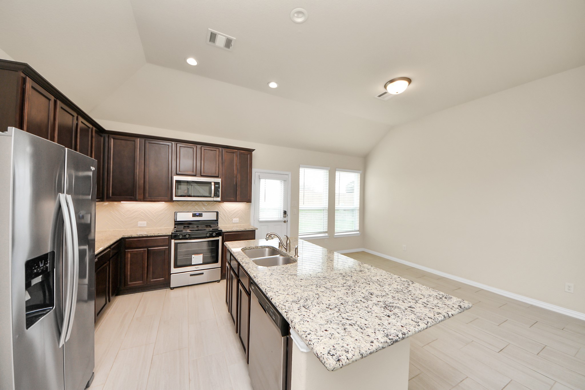 32903 Silver Meadow Way Brookshire, TX 77423 - Photo 13 of 40 a kitchen with stainless steel appliances granite countertop a sink stove and refrigerator