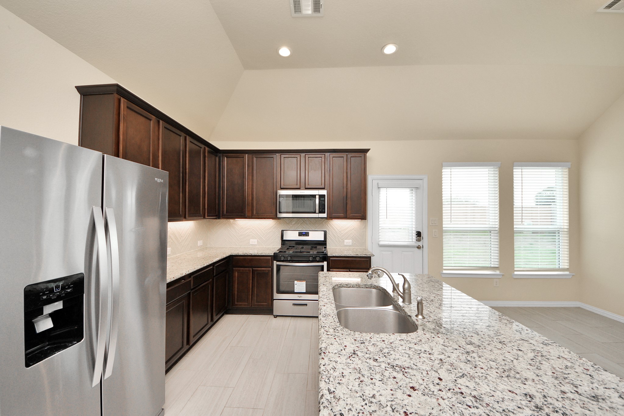 32903 Silver Meadow Way Brookshire, TX 77423 - Photo 14 of 40 a kitchen with granite countertop a refrigerator and a sink