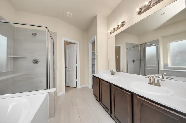 a bathroom with a double vanity sink mirror double and shower