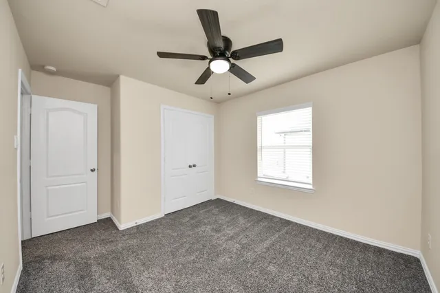 a view of empty room with ceiling fan