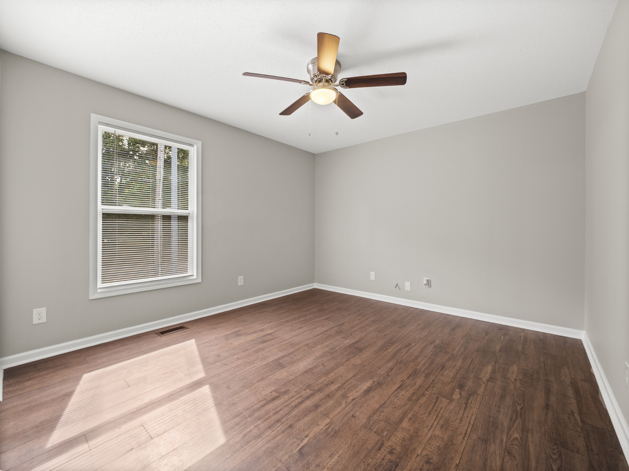 1883 Needmore Road Clarksville, TN 37042 - Photo 14 of 25 an empty room with wooden floor ceiling fan and windows