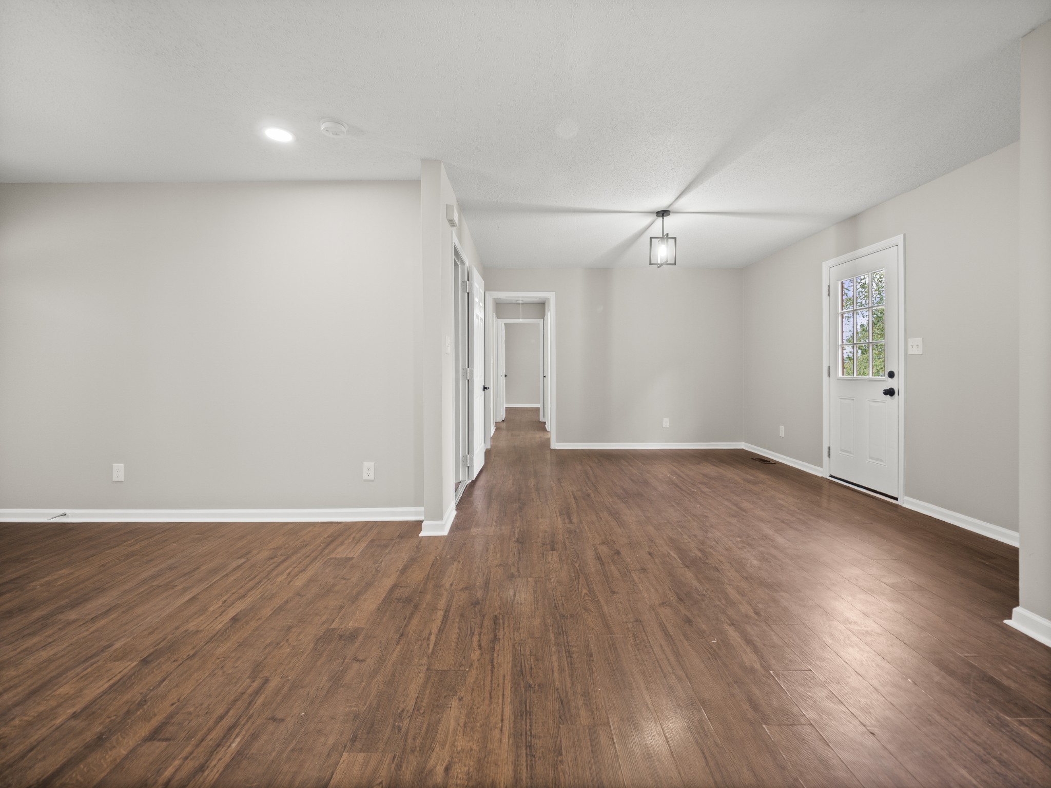 1883 Needmore Road Clarksville, TN 37042 - Photo 7 of 25 a view of an empty room with wooden floor and a ceiling fan
