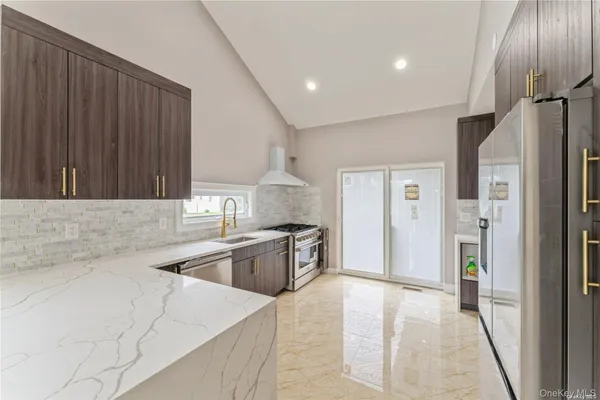 a kitchen with stainless steel appliances granite countertop a refrigerator and a sink