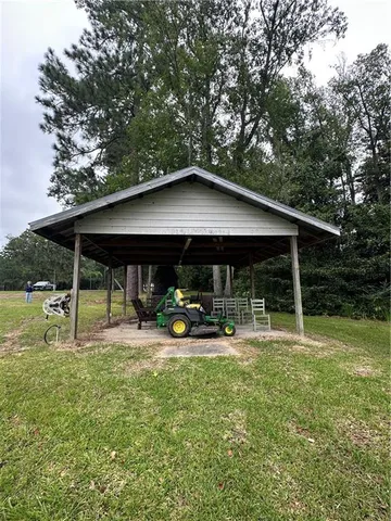 a backyard of a house with table and chairs under an umbrella