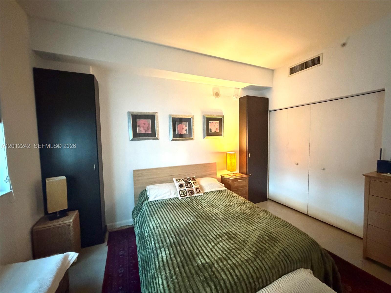 234 Northeast 3rd Street, Unit 1908 Miami, FL 33132 - Photo 11 of 16 a bedroom with a bed and wooden floor
