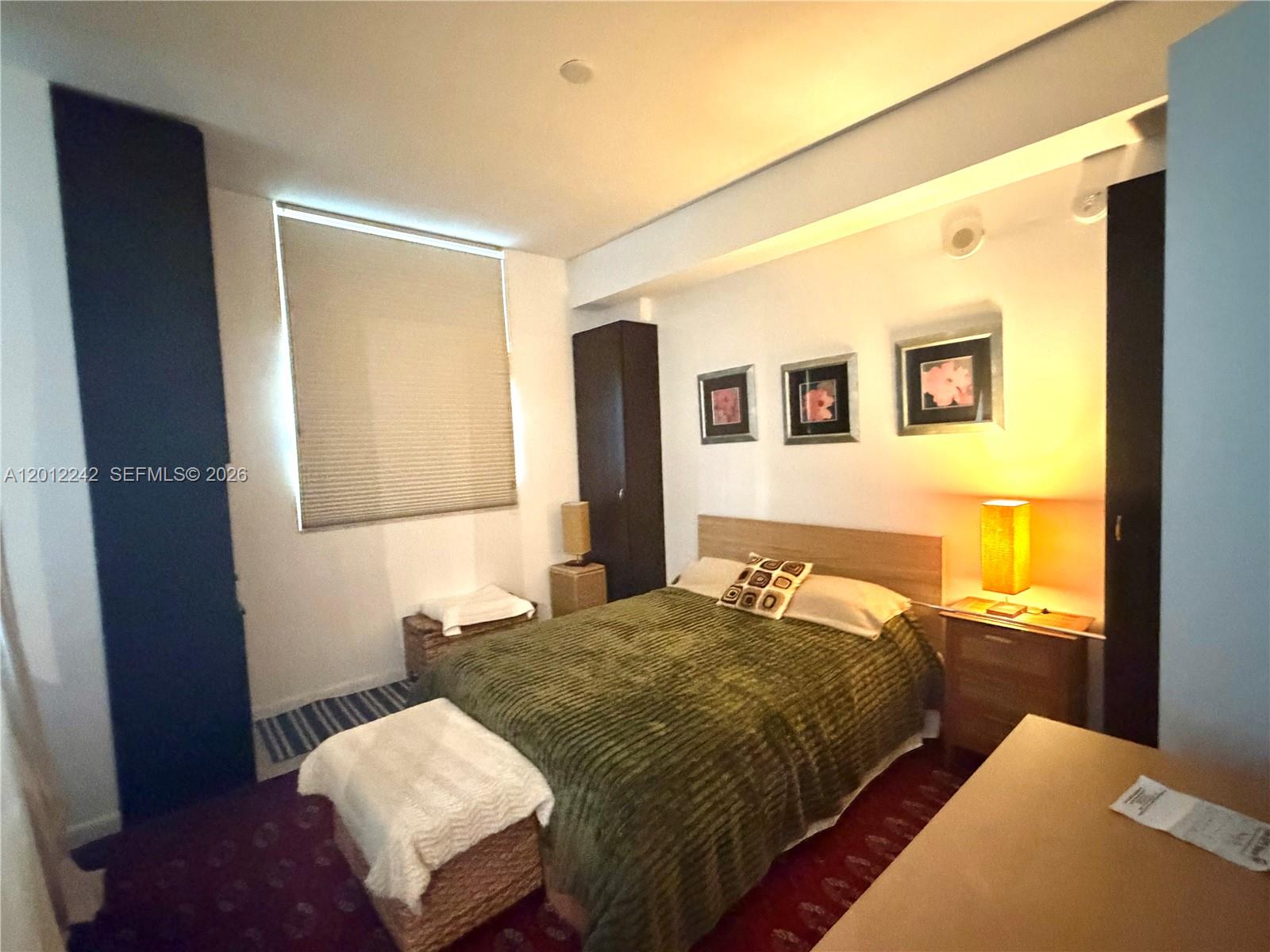 234 Northeast 3rd Street, Unit 1908 Miami, FL 33132 - Photo 12 of 16 a bedroom with a bed and wooden floor