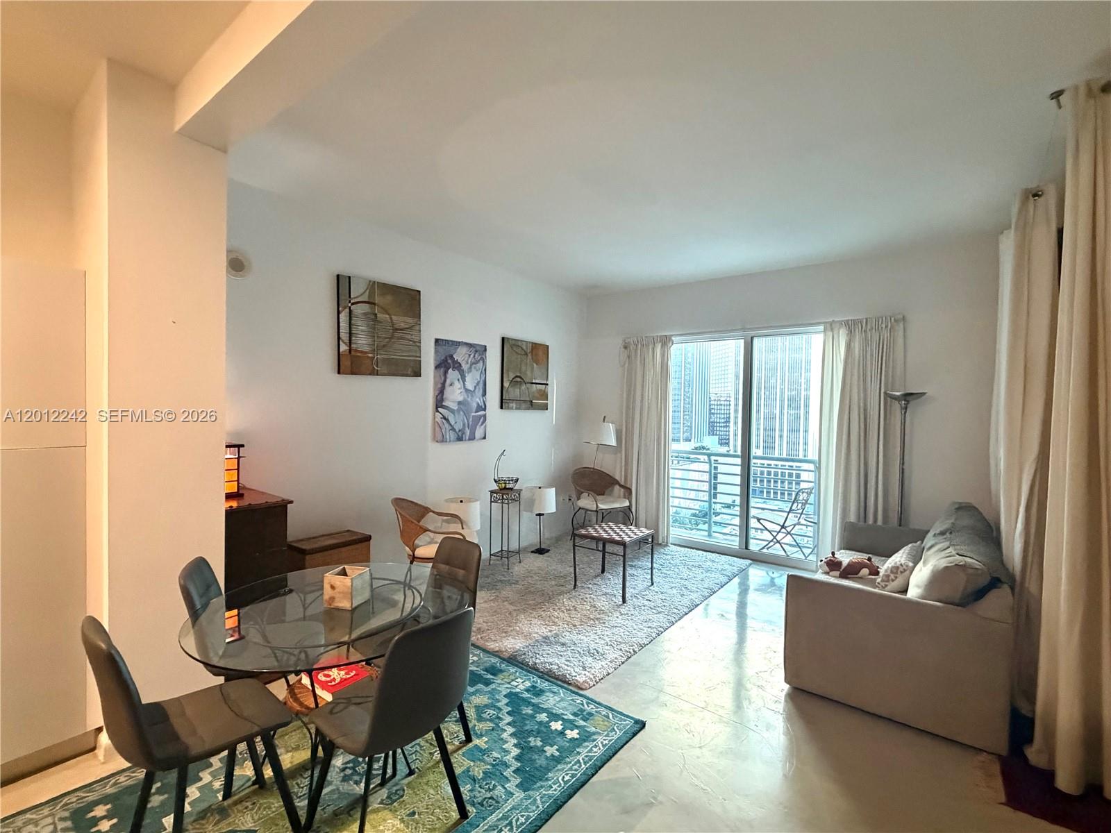 234 Northeast 3rd Street, Unit 1908 Miami, FL 33132 - Photo 2 of 16 a living room with furniture and a large window