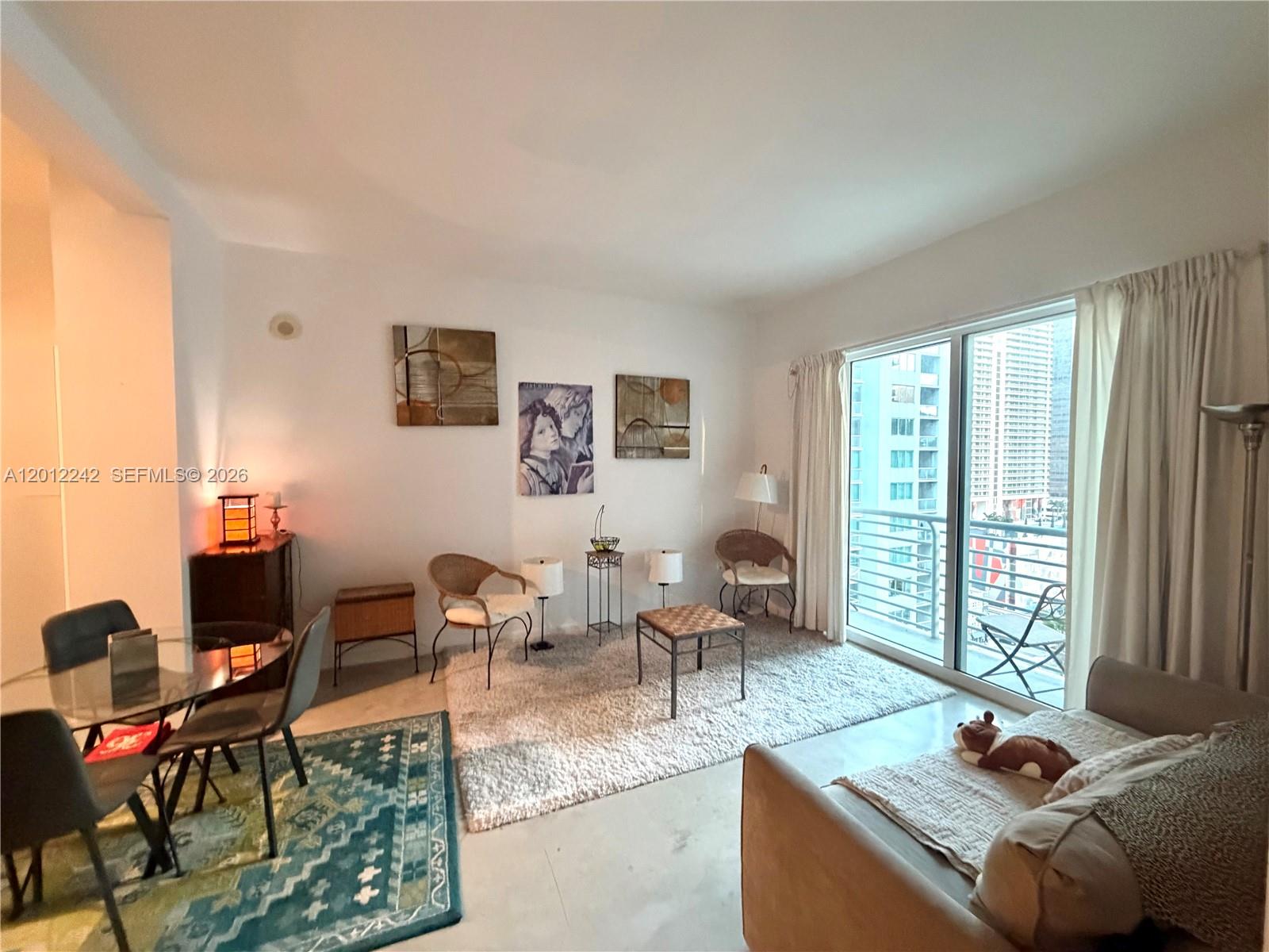 234 Northeast 3rd Street, Unit 1908 Miami, FL 33132 - Photo 7 of 16 a living room with furniture and large window
