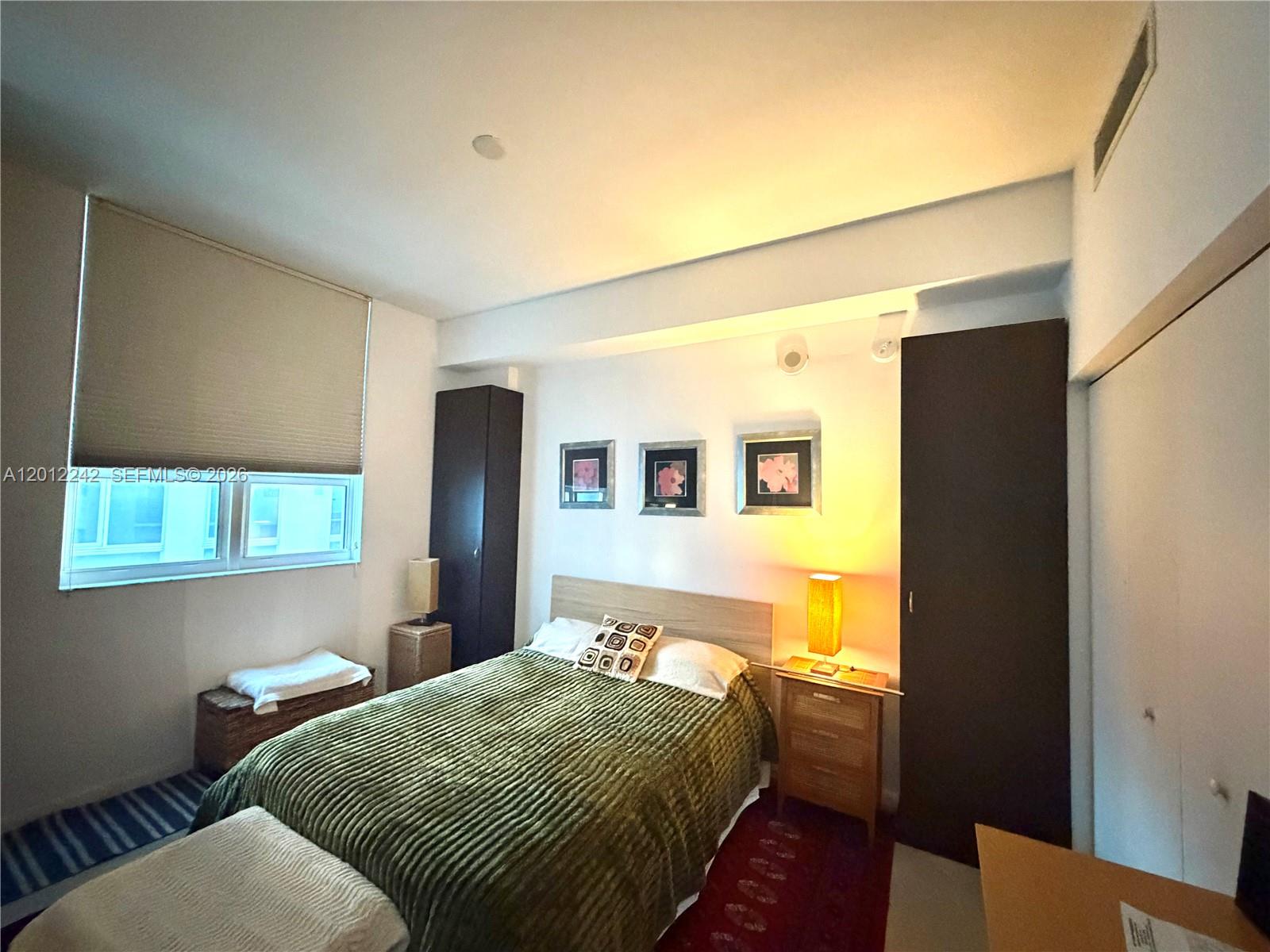 234 Northeast 3rd Street, Unit 1908 Miami, FL 33132 - Photo 8 of 16 a bedroom with a bed and wooden floor