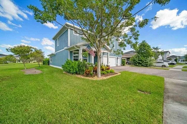a view of a house with backyard and a tree