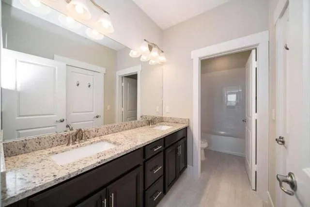 a bathroom with a granite countertop sink and a mirror