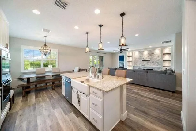 a kitchen with kitchen island granite countertop lots of counter top space and stainless steel appliances