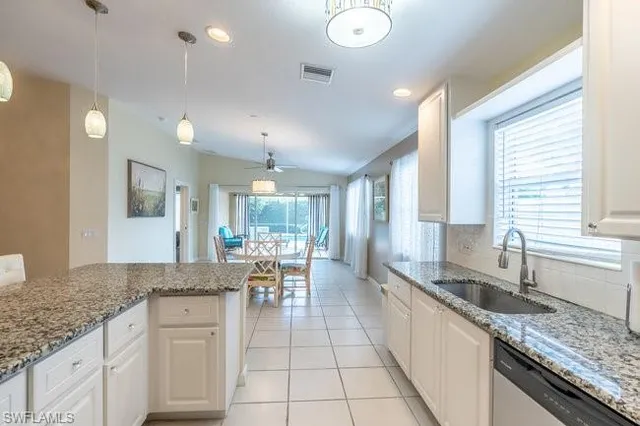 a large kitchen with granite countertop a sink and a counter top space
