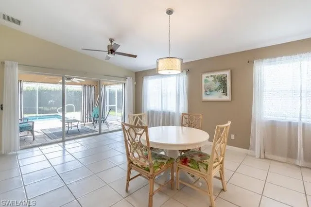 a view of a dining room and livingroom with furniture wooden floor a chandelier