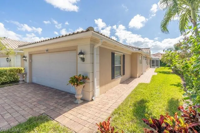 a view of a white house with a large tree