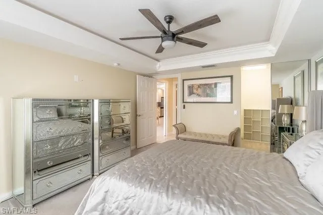 a bedroom with a large bed and a chandelier