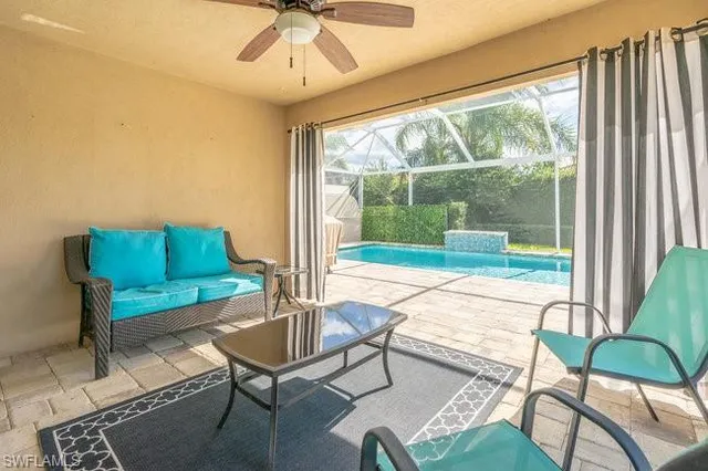 a living room with furniture and a large window with garden view
