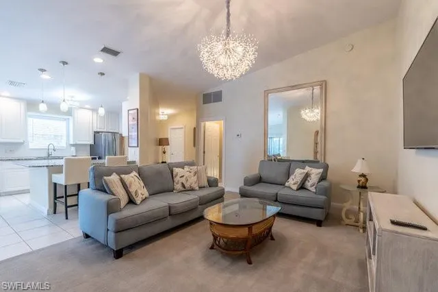 a living room with furniture and a chandelier