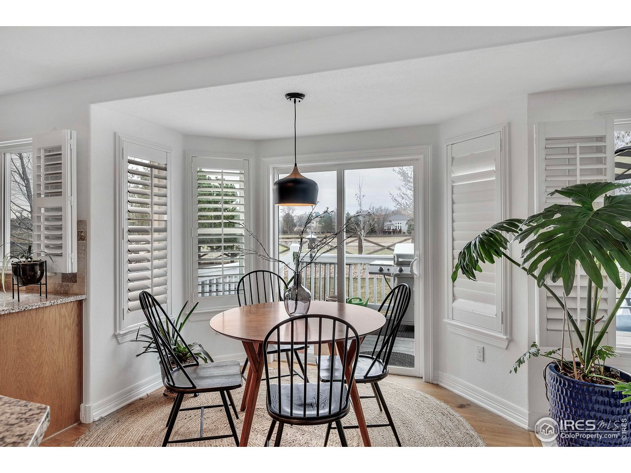 3058 West 111th Drive Westminster, CO 80031 - Photo 13 of 39 a dining room with furniture potted plants and wooden floor