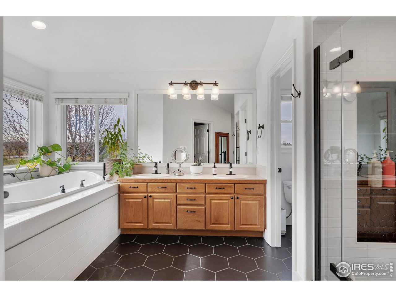 3058 West 111th Drive Westminster, CO 80031 - Photo 19 of 39 a bathroom with a sink a large mirror and a bathtub