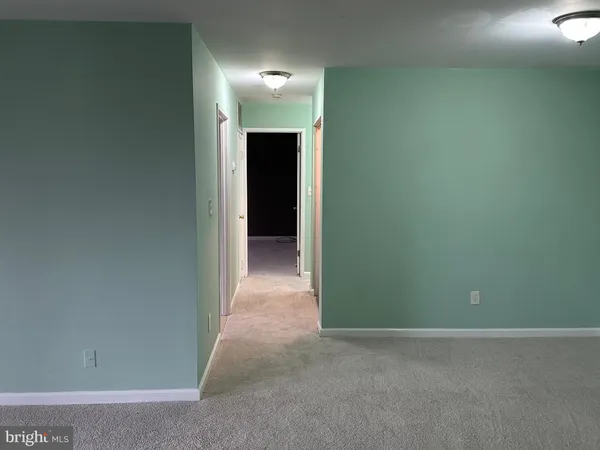 a view of an empty room with closet and a window