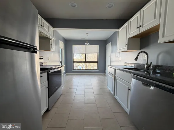 a kitchen with stainless steel appliances a refrigerator sink and microwave