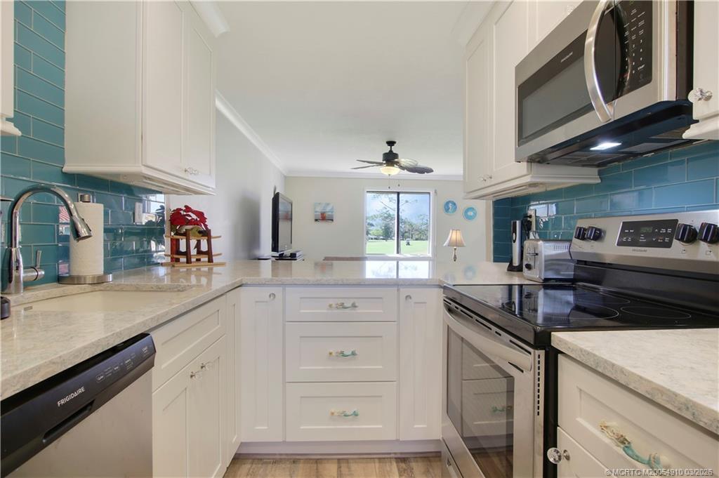 5323 Southeast Miles Grant Road, Unit 206 Stuart, FL 34997 - Photo 4 of 20 a kitchen with stainless steel appliances granite countertop a sink and cabinets