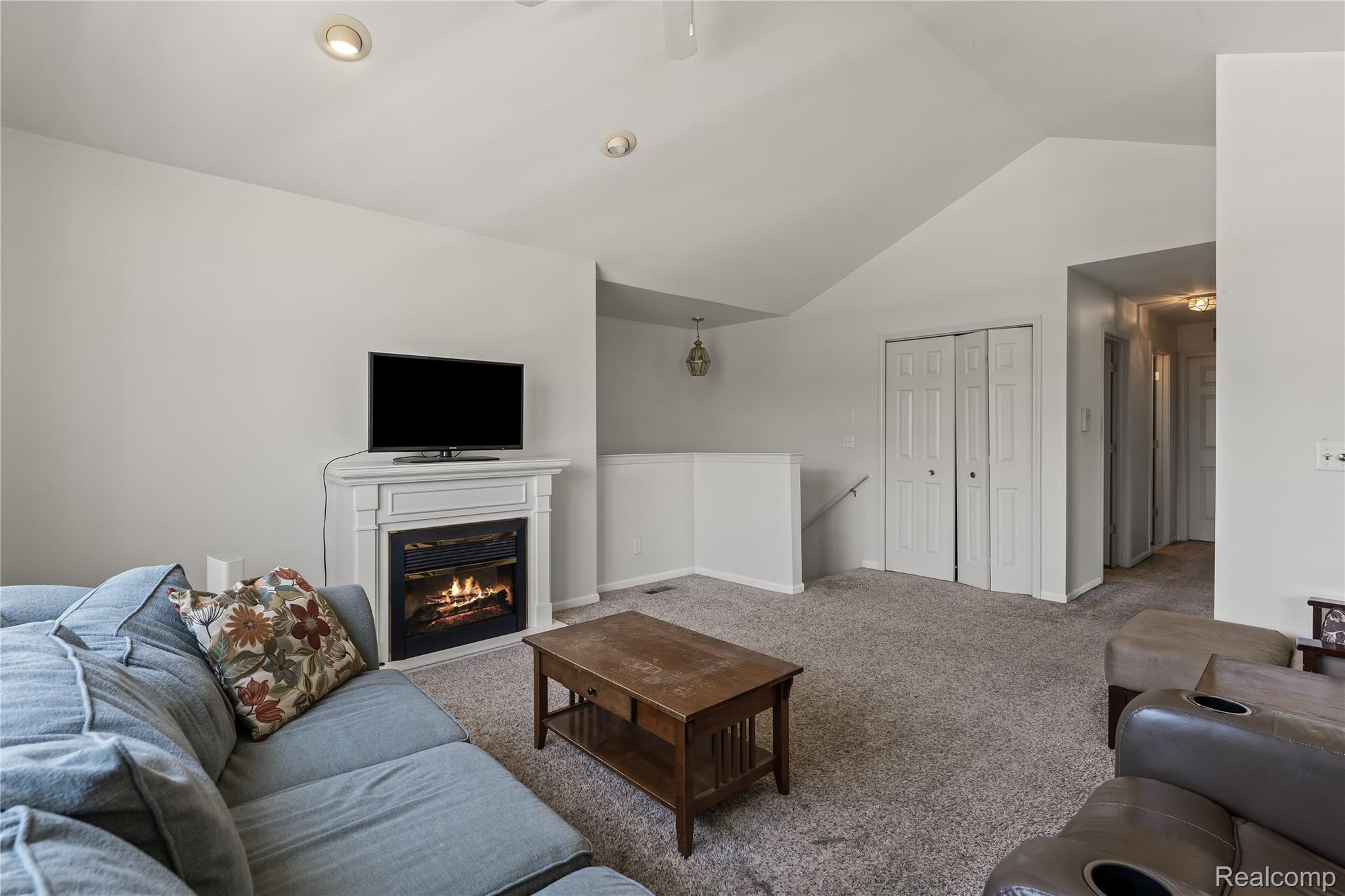 1861 Flagstone Circle Rochester, MI 48307 - Photo 6 of 21 Living area featuring a fireplace with a white mantel, recessed lighting, vaulted ceiling, and carpeted flooring