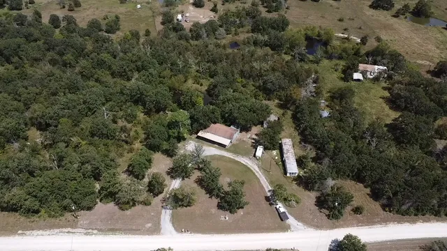 an aerial view of a house with a yard and trees