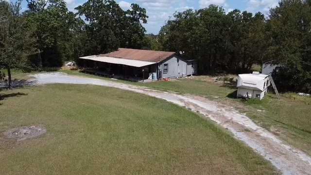 a view of a backyard with a small cabin and wooden fence