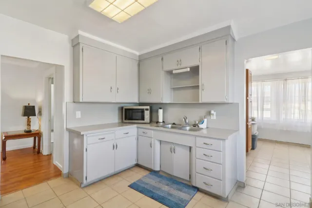 a kitchen with white cabinets and sink