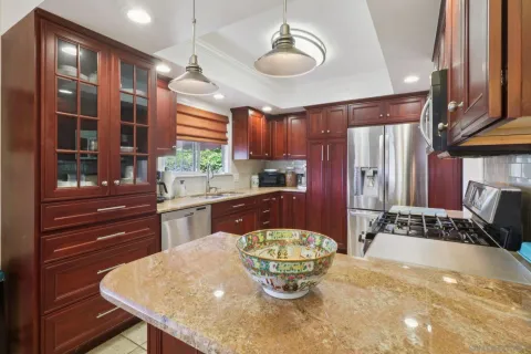 a kitchen with a stove a refrigerator and a dining table with wooden floor