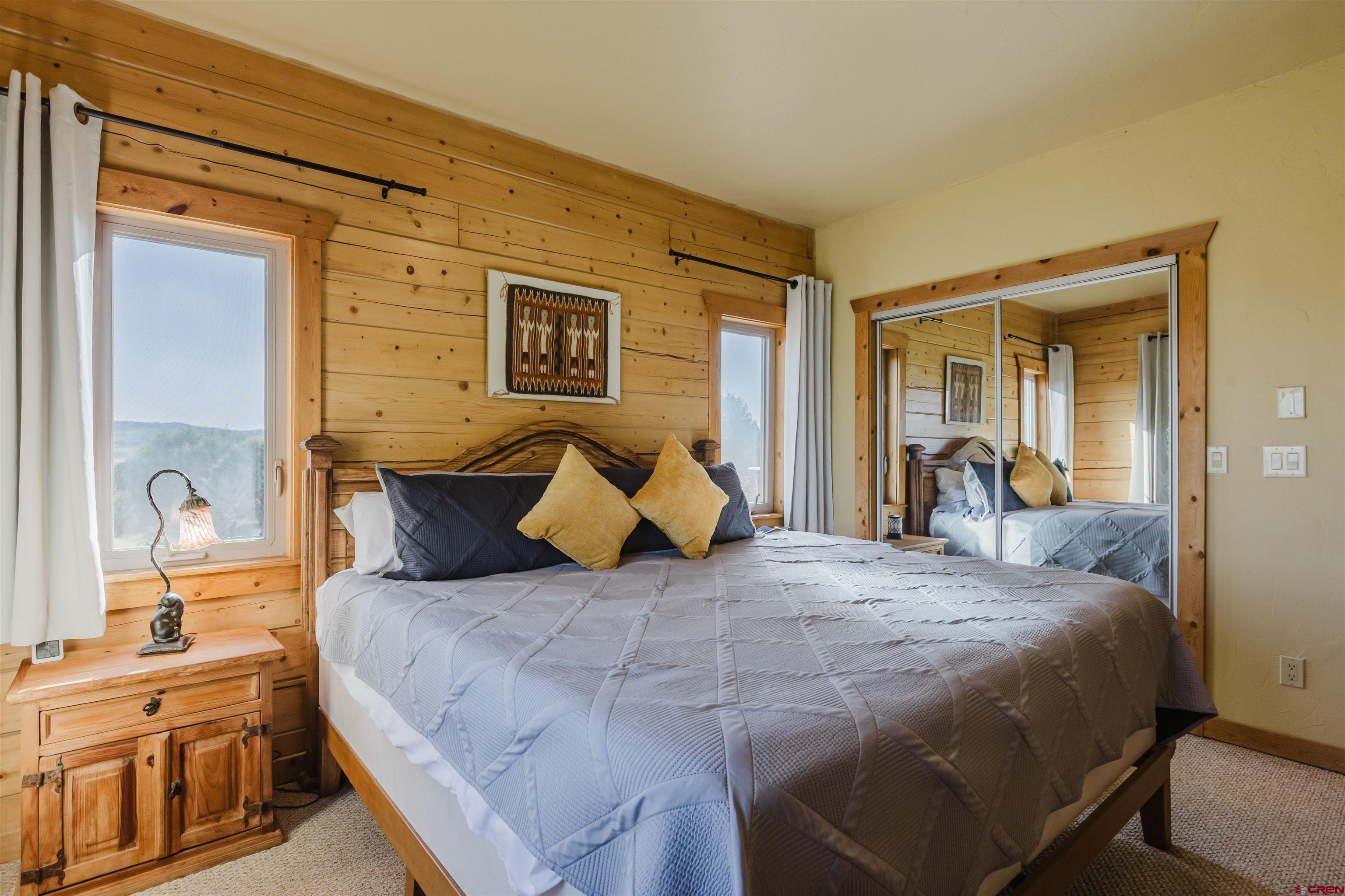 2439 County Road 359 Pagosa Springs, CO 81147 - Photo 30 of 45 a bedroom with a bed and a large mirror with a dresser