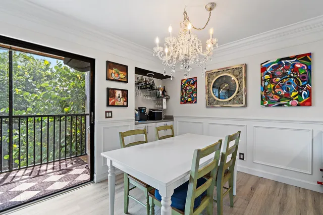 a view of a dining room with furniture a chandelier and wooden floor