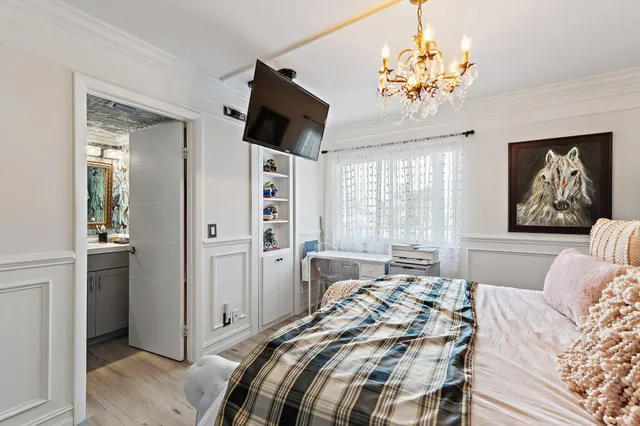 a bedroom with a bed and a chandelier