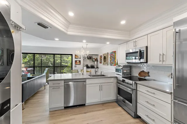 a kitchen with stainless steel appliances kitchen island granite countertop a sink and cabinets