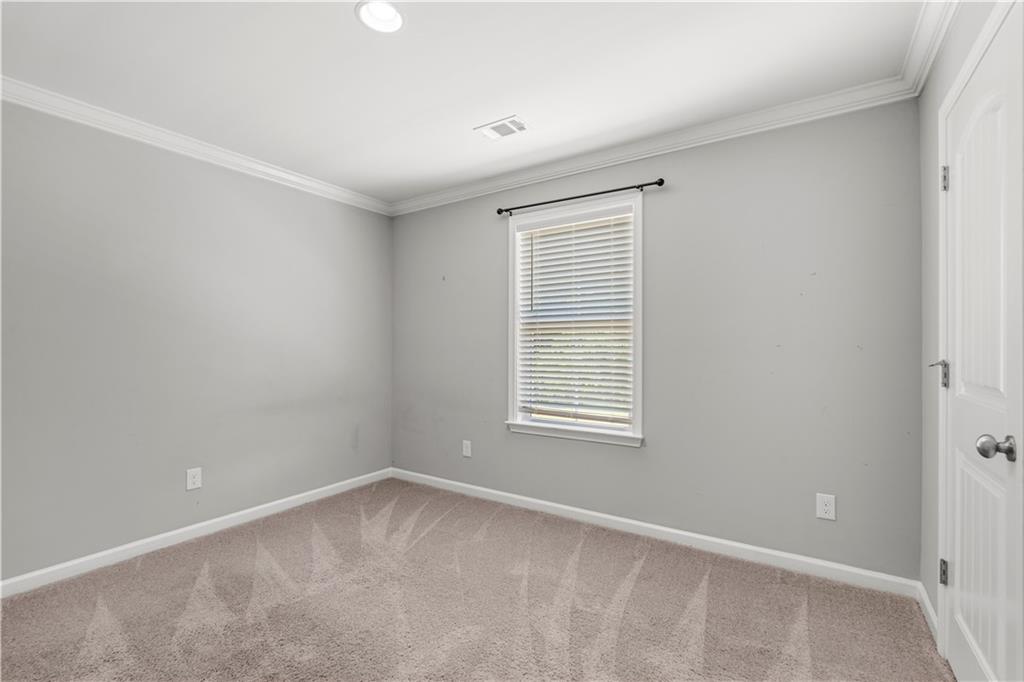 690 Bush Creek Road Opelika, AL 36804 - Photo 22 of 31 Neutral-toned room featuring a single window with blinds, light gray walls, and plush carpet flooring