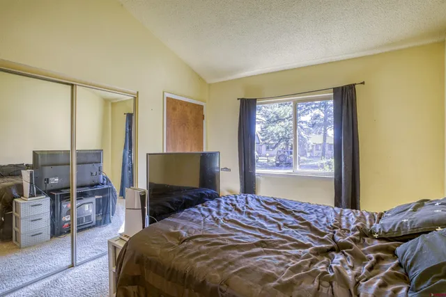 a bedroom with a bed and flat screen tv