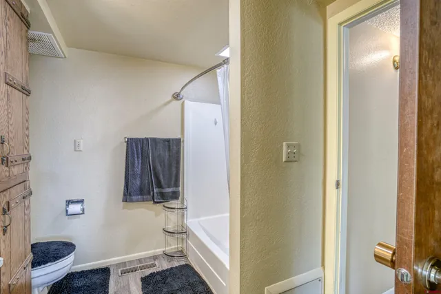 a bathroom with a tub and toilet