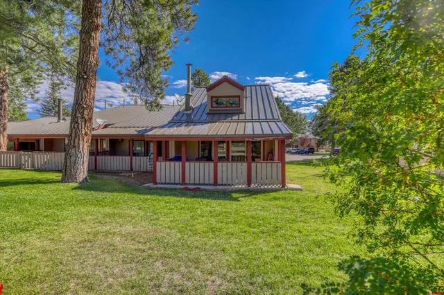 a view of a house with a yard and a wooden deck